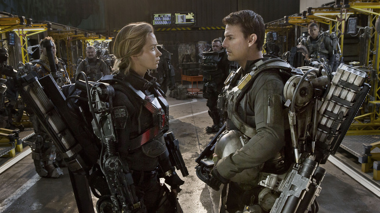 Cage and Rita face each other in cybernetic battle armor in a training hangar in "Edge of Tomorrow" (2014)