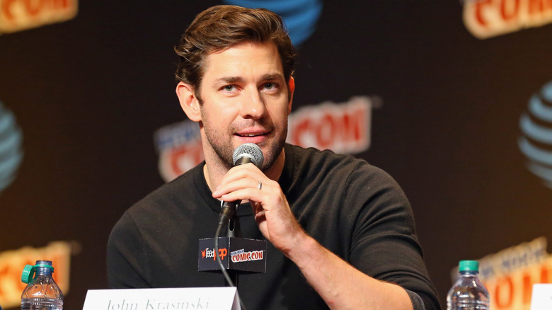 John Krasinski holding a mic at a Comic-Con panel