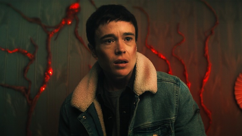 Viktor Hargreeves wears a denim jacket in a room covered in blood red veins in "The Umbrella Academy"