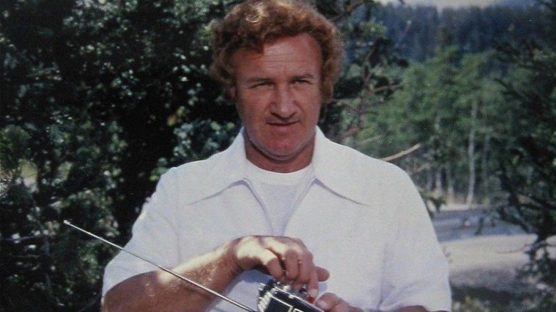 Lex Luthor holding a controller outside in 