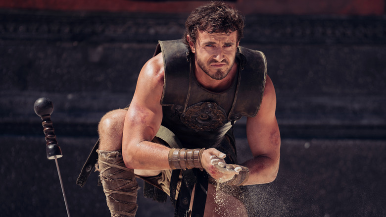 Lucius Aurelius rubbing sand between his hands in "Gladiator II"