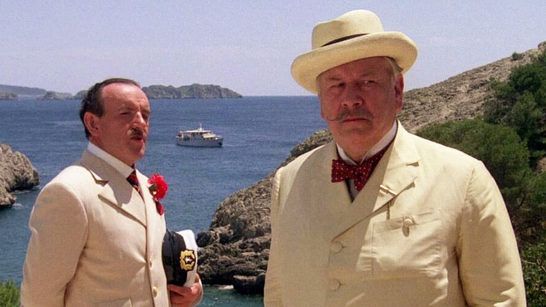 Two men standing on a beach in "Evil Under the Sun."