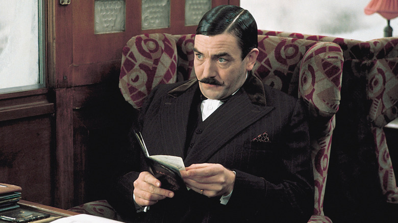Hercule Poirot sitting in a chair in 