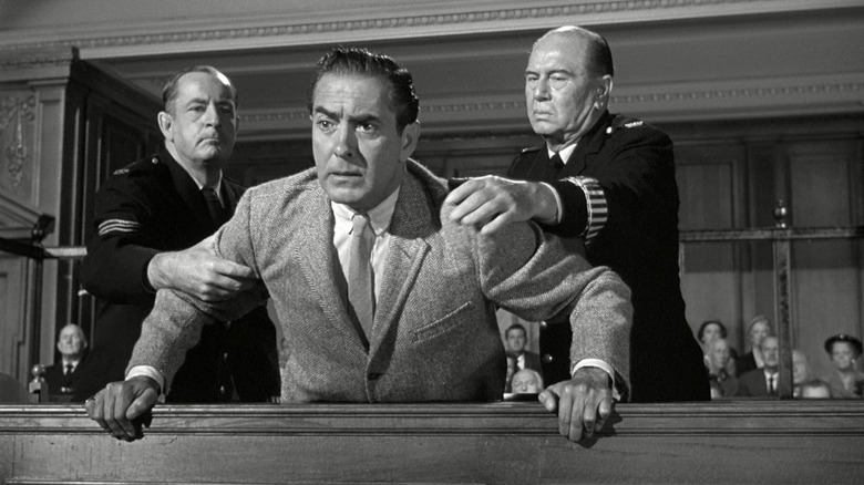 Two men holding another back in "Witness for the Prosecution."