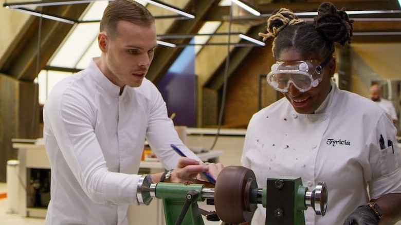 Two people at a chocolate spinning wheel in School of Chocolate (2021)