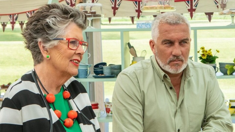 Prue and Paul sitting side by side in The Great British Baking Show (2010)