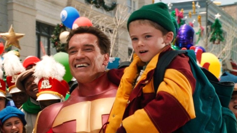 Howard Langston holds Jamie while wearing the Turbo Man suit in Jingle All the Way (1996)