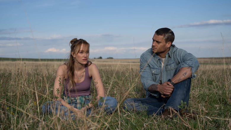 Kenna and Ledger sitting in tall grass outside in Reminders of Him (2026)