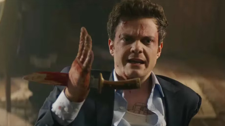 Nathan sitting on the floor with a dagger shoved through his hand