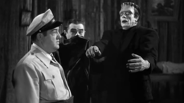 Lou Costello's Wilbur Grey standing with Bela Lugosi's Dracula and Glenn Strange's Frankenstein's Monster in Abbott and Costello Meet Frankenstein