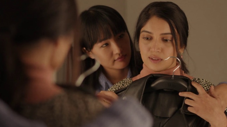 Rimjhim holding a leather jacket in front of Sumi in a fitting room in Badhaai Do