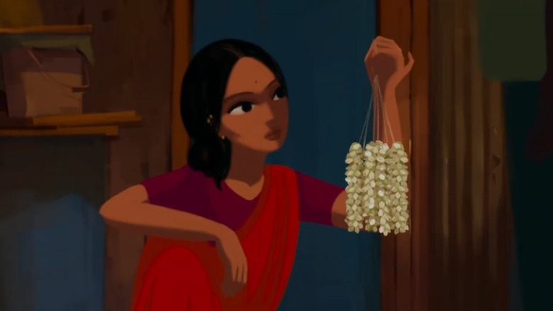 Kamala holding a set of leaves by a string in Bombay Rose