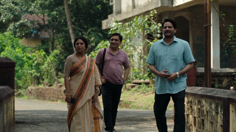 Shailaja, Dipankar, and Pradeep standing on a bridge in Three of Us