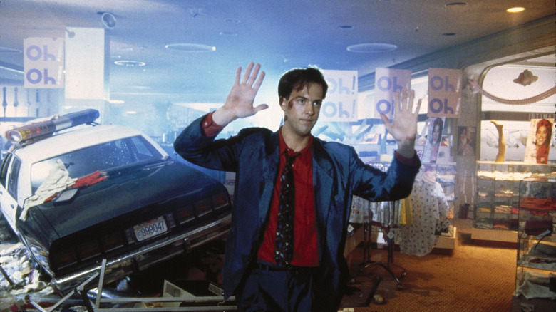 Harry Washello raises his hands in a shopping mall in Miracle Mile