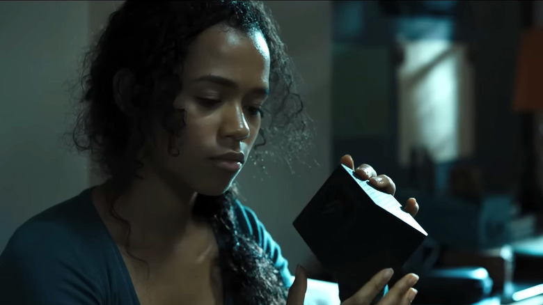 Taylor Russell's Zoey Davis looking at a puzzle box in Escape Room