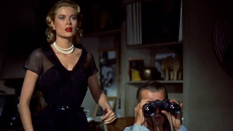 Lisa looking shocked and Jeff looking through binoculars in Jeff's apartment in Rear Window