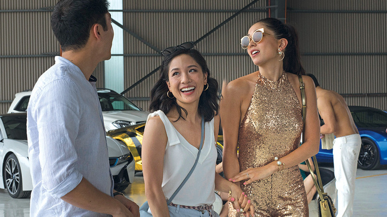 Rachel and Araminta talking to Nick in an airplane hangar in Crazy Rich Asians