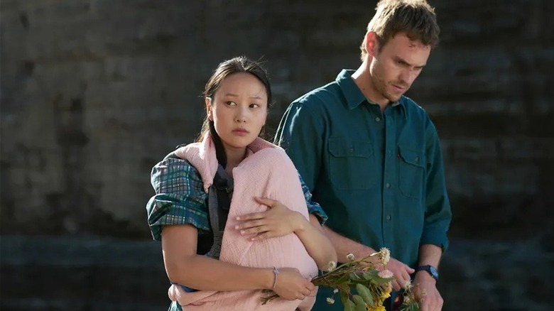 Kieran and Mia walk by a cliffside in The Survivors