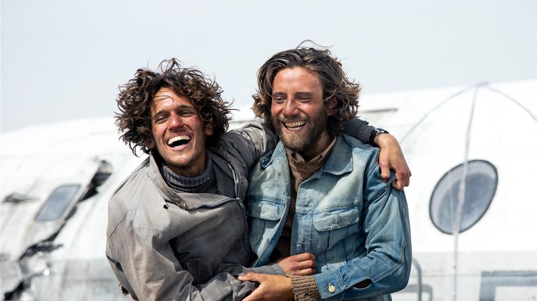 Survivors smiling and embracing in Society of the Snow (2023)