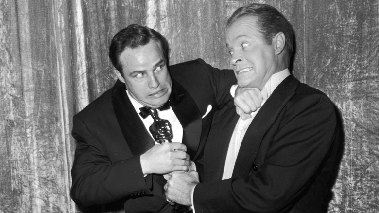 Bob Hope and Marlon Brando pretend to wrestle over an Oscar