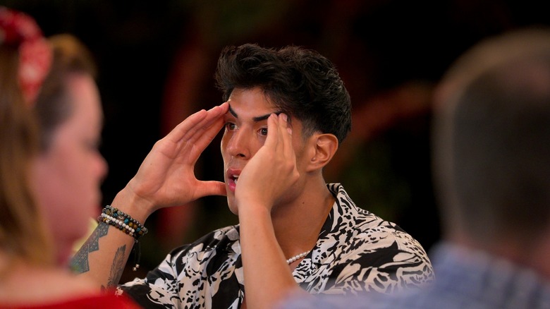 Tony clutching his temples in shock on "The Mole" Season 2