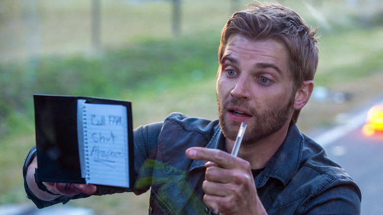 Dale pointing to writing on a notepad in "Under the Dome."