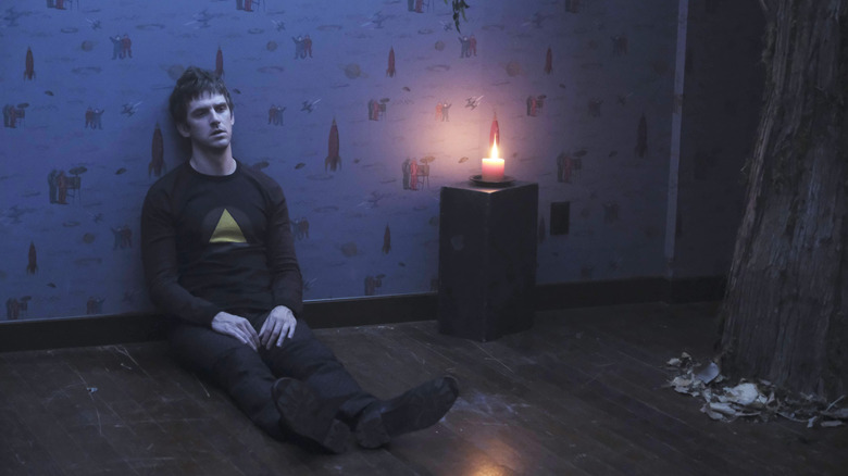 David sitting on floor, looking disoriented in Legion