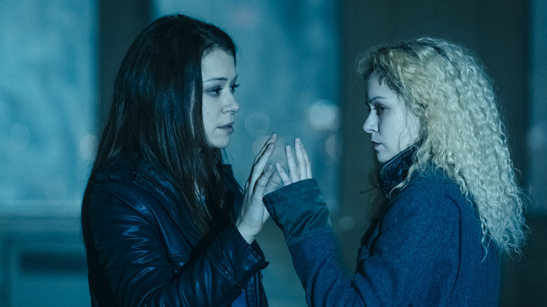 Sarah and Helena touch hands in Orphan Black