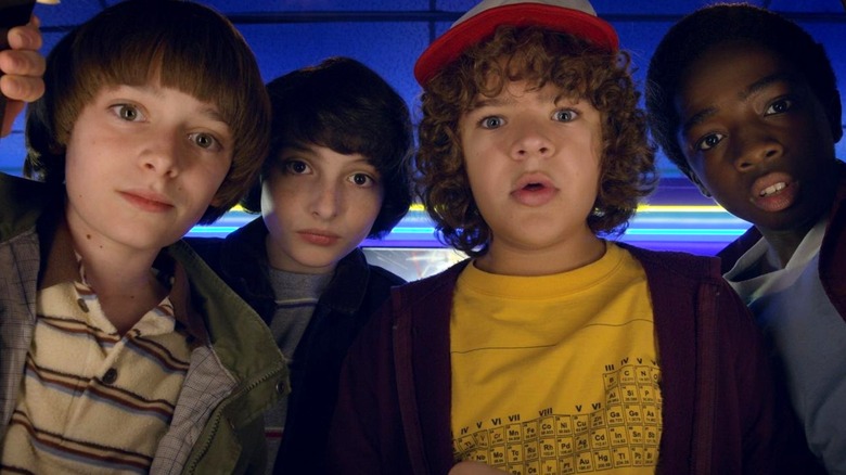 Will, Mike, Dustin, and Lucas playing an arcade game in 