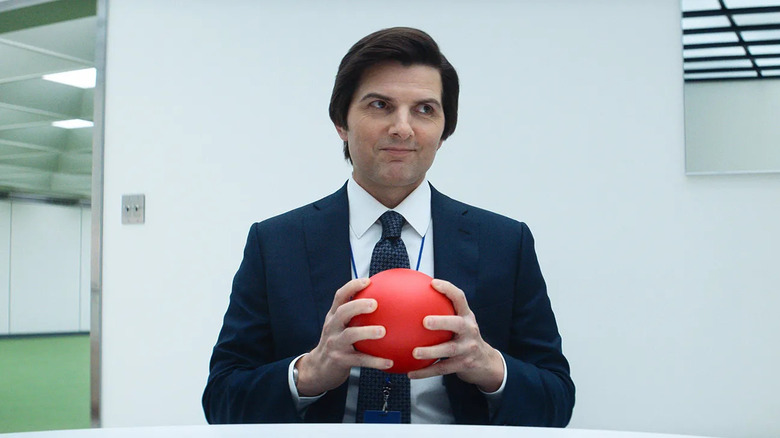 Mark S. holding a red ball and smirking on Severance