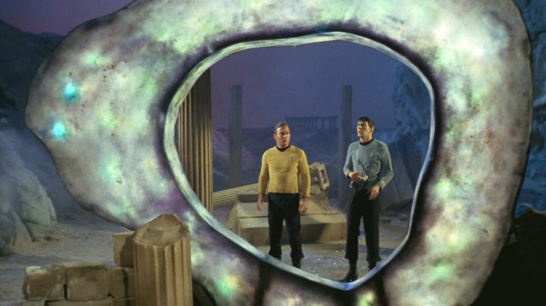 Captain Kirk and Spock in front of a silvery portal in "Star Trek"
