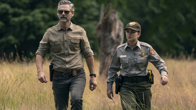 Naya and Kyle walk through a field in Untamed