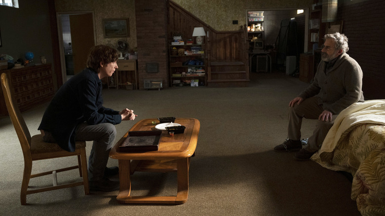 Sam sitting in front of a coffee table talking to an imprisoned Alan on The Patient