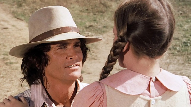Charles Ingalls kneels to talk to one of his daughters on Little House on the Prairie