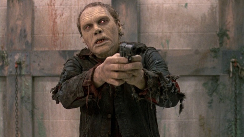 Bub the zombie points a gun in "Day of the Dead" (1985)