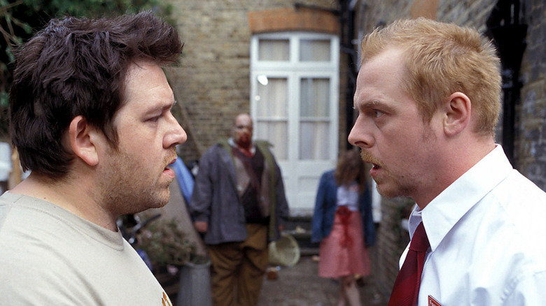 Shaun and Ed chat as zombies approach in "Shaun of the Dead" (2004)