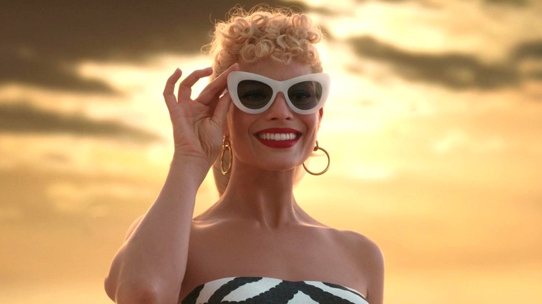 A smiling Barbie wearing sunglasses in Barbie (2023)