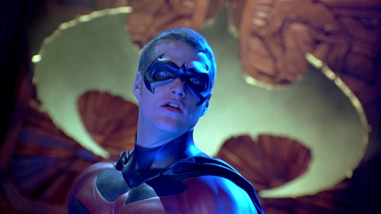 Robin standing in front of the Robin logo in Batman & Robin