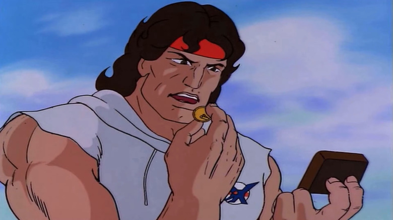John Rambo looking at a coin in Rambo: The Force of Freedom