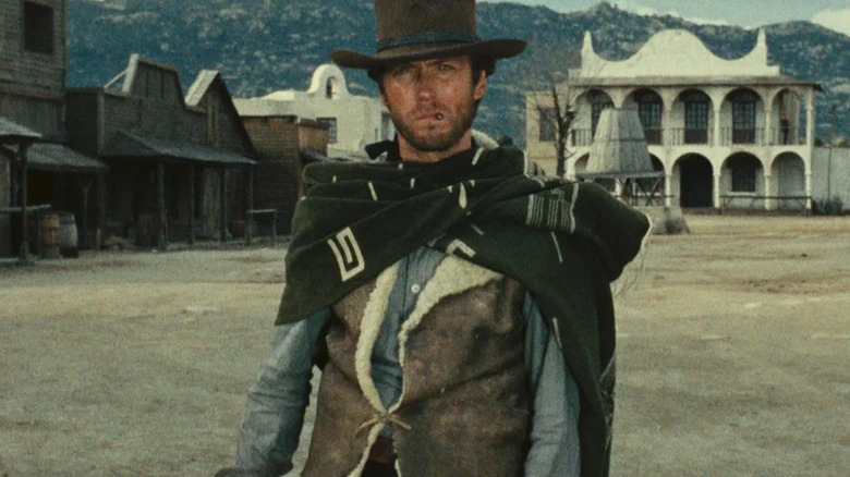 The Man With No Name stands alone, smoking in town, in A Fistful of Dollars (1964)