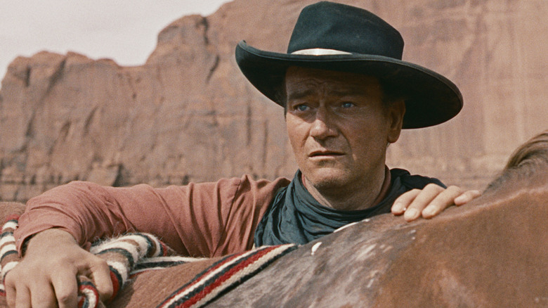 Ethan Edwards looks out over his horse in The Searchers (1956)