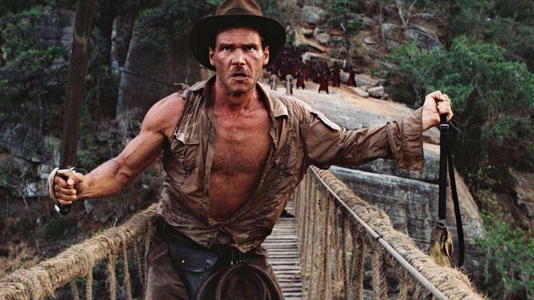Indiana Jones holds a machete on a bridge in "Indiana Jones and the Temple of Doom" (1984)