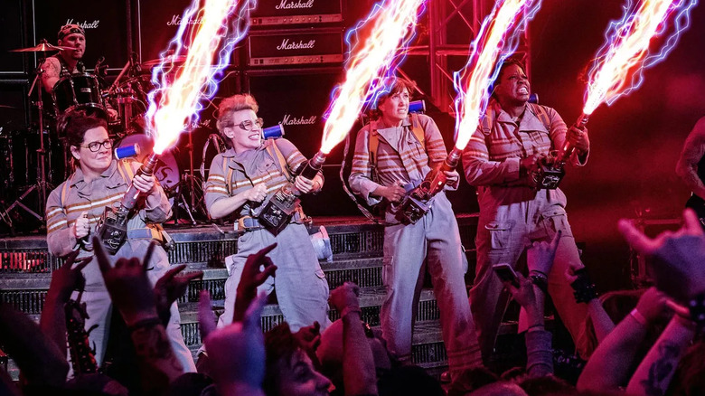 The Ghostbusters fire their proton packs at a rock concert in Ghostbusters (2016)