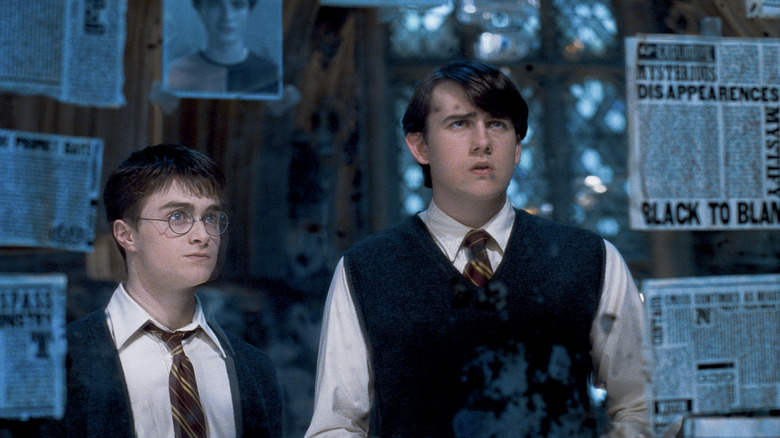 Harry and Neville looking at newspapers and pictures in Harry Potter and the Order of the Phoenix