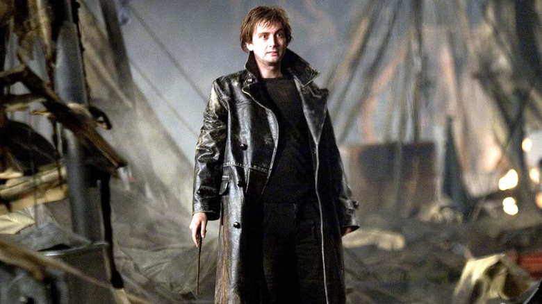 Barty Crouch Jr. standing between tents at the Quidditch World Cup holding his wand