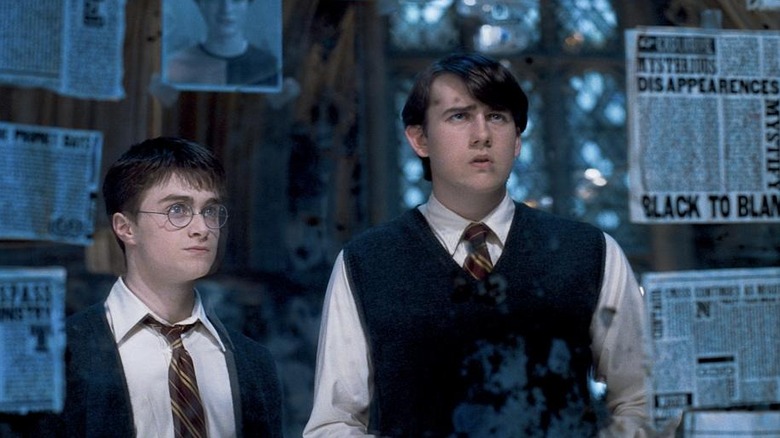 Harry and Neville looking at newspapers and pictures in Harry Potter and the Order of the Phoenix