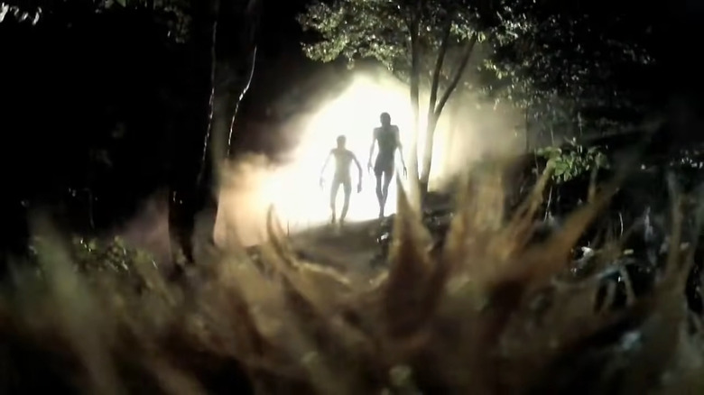 Alien figures in front of lights 