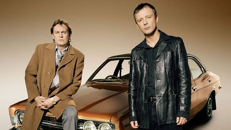 Gene and Sam next to a car, frowning, in "Life on Mars."