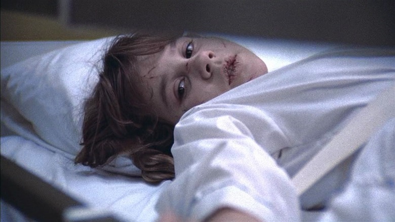 Linda Blair as Regan in The Exorcist, lips chapped, scratches on her face in a hospital bed