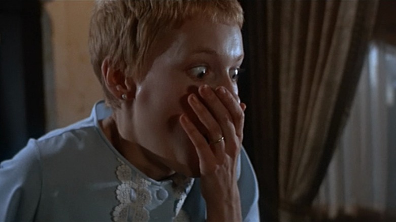 Mia Farrow as Rosemary in Rosemary's Baby covers her mouth in wide-eyed horror